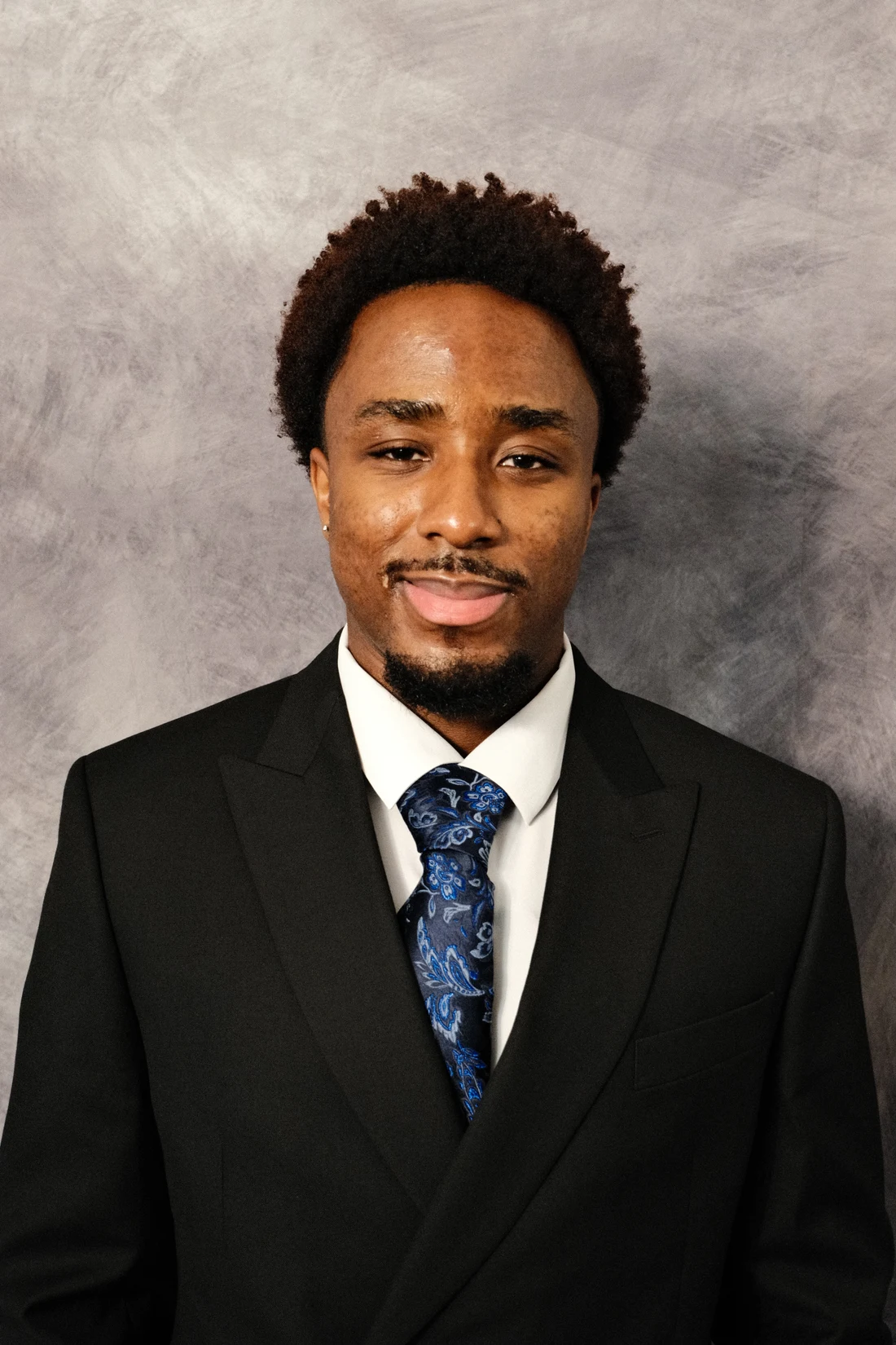 Michel Brian Nguegang wearing a dark suit and blue tie